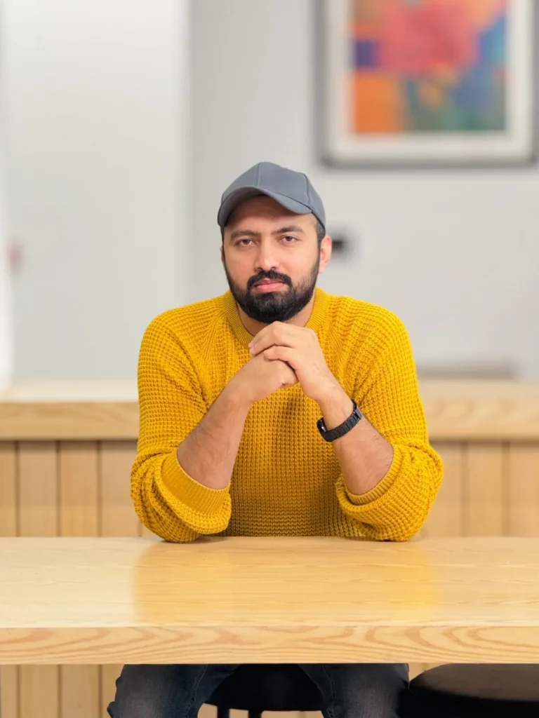 Usama Tanveer seated at a wooden desk