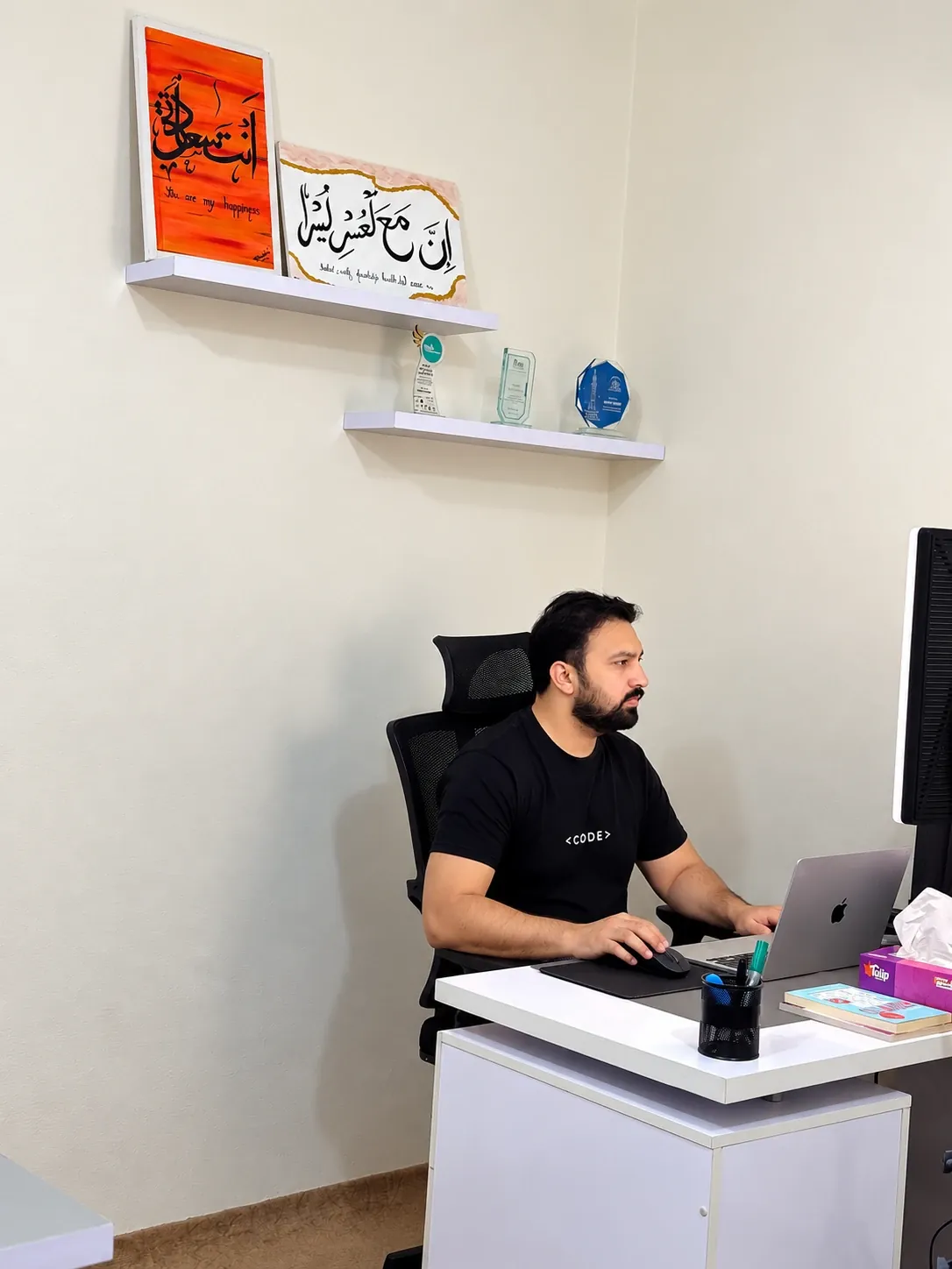 Usama Tanveer working at his desk in his office